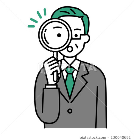 A middle-aged man in a suit looking through a magnifying glass 130040691