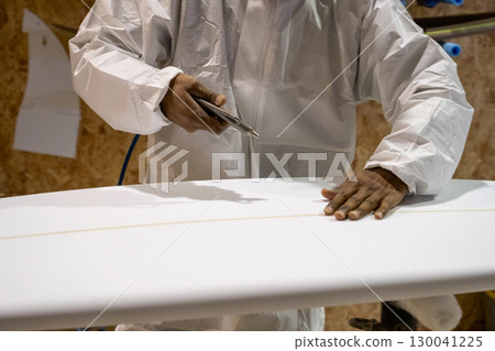 Shaper working on surf board 130041225