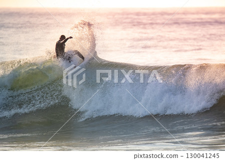 Young surfer enjoying waves 130041245