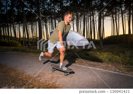 Surf skater rolling by the pine forest at sunset Surf skater rolling by the pine forest at sunset 130041421