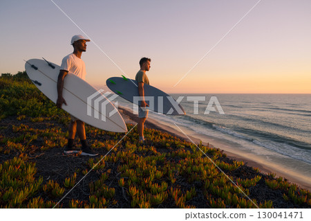 Surfers watching the waves at sunset Surfers watching the waves at sunset 130041471