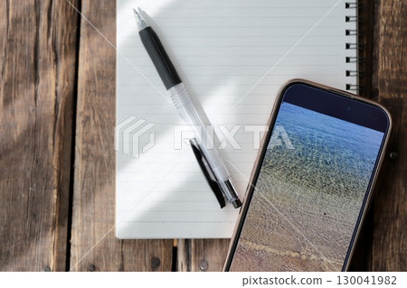 A smartphone, a ring notebook, and a pen to organize ideas 130041982