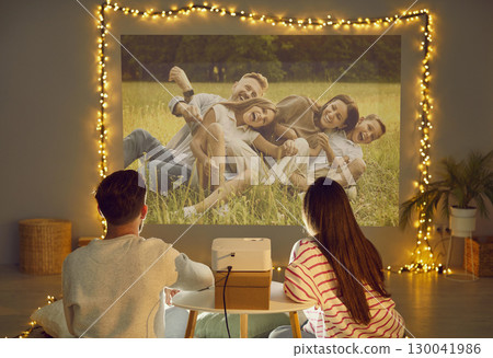 Projection family pictures on wall, using video projector, happy people in love sitting close 130041986