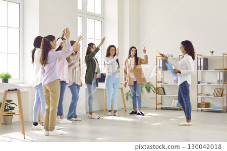 Happy motivated employees raising hands asking coach or voting at training 130042018