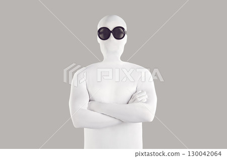 Portrait of man disguised in white bodysuit and black sunglasses standing with folded arms Portrait of man disguised in white bodysuit and black sunglasses standing with folded arms 130042064