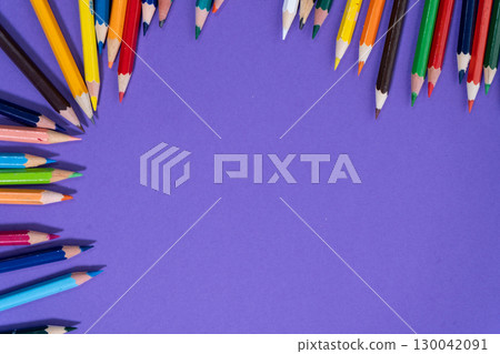 Colored pencils forming a colorful frame on purple background 130042091