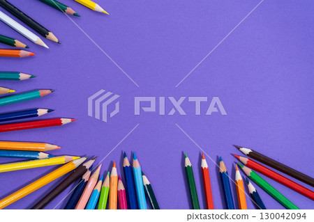 Colored pencils forming a colorful border on purple background Colored pencils forming a colorful border on purple background 130042094