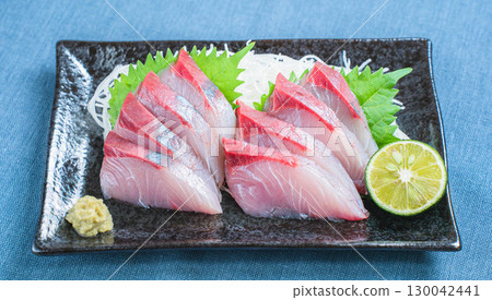 Japanese dish of yellowtail sashimi with daikon radish and sudachi citrus Japanese dish of yellowtail sashimi with daikon radish and sudachi citrus 130042441