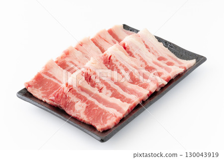 Beef ribs (beef belly) for grilling served on a plate on a white background 130043919