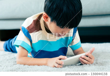 Boy playing with a smartphone 130044138