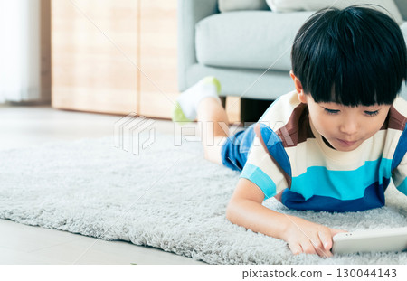Boy playing with a smartphone 130044143