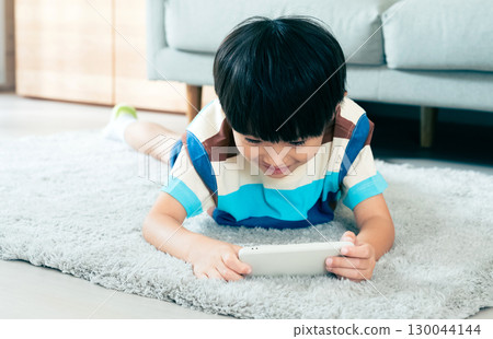 Boy playing with a smartphone 130044144