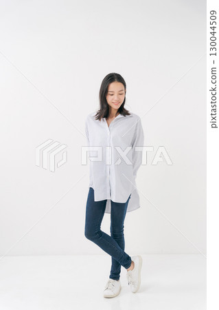 穿著休閒襯衫和牛仔褲的微笑女人 130044509