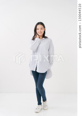 穿著休閒襯衫和牛仔褲的微笑女人 穿著休閒襯衫和牛仔褲的微笑女人 130044510