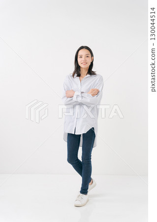 穿著休閒襯衫和牛仔褲的微笑女人 穿著休閒襯衫和牛仔褲的微笑女人 130044514