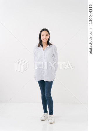 穿著休閒襯衫和牛仔褲的微笑女人 穿著休閒襯衫和牛仔褲的微笑女人 130044516