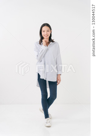穿著休閒襯衫和牛仔褲的微笑女人 130044517