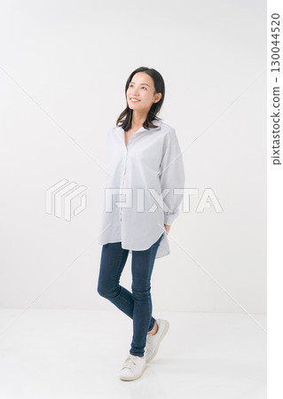 穿著休閒襯衫和牛仔褲的微笑女人 130044520