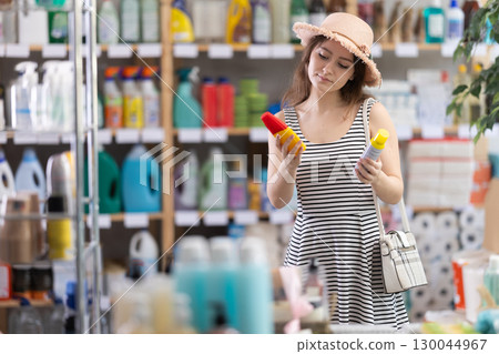Woman choosing insect repellent in supermarket 130044967