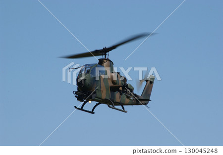 An attack helicopter seen from the front against a blue sky 130045248