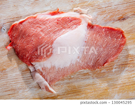Raw pork on wooden surface with ingredients 130045295
