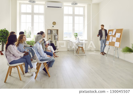 Man showing his colleagues financial data in office analyzing company growth on meeting 130045507