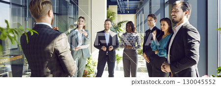 Group of business people on a meeting discussing work project standing in a row in office. Group of business people on a meeting discussing work project standing in a row in office. 130045552