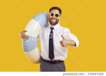 Man in office clothes showing thumb up sign on yellow background going on summer trip 130045569