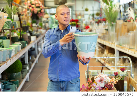 Man photographing flower pot in store Man photographing flower pot in store 130045575