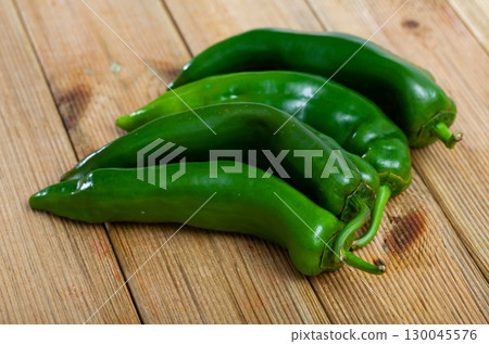 Whole and sliced fresh bell pepper on wooden table. Healthy vegetarian ingredient 130045576
