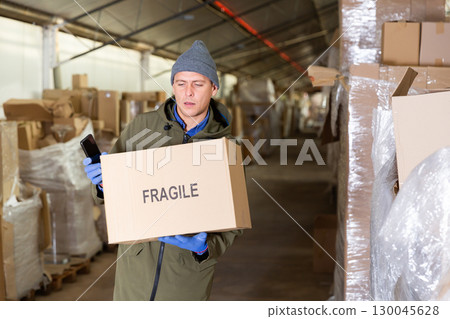 Loader stacks various boxes on racks in store 130045628