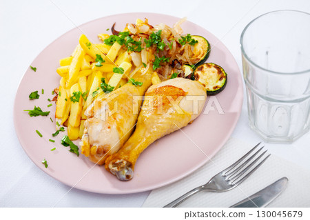 Dish with baked chicken legs and zucchini 130045679