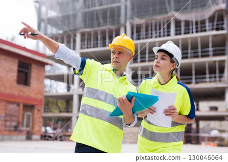 Civil engineers checking work process in construction site 130046064