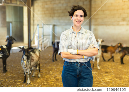Happy Latin female farmer with crossed hands on chest on goat cattle farm Happy Latin female farmer with crossed hands on chest on goat cattle farm 130046105