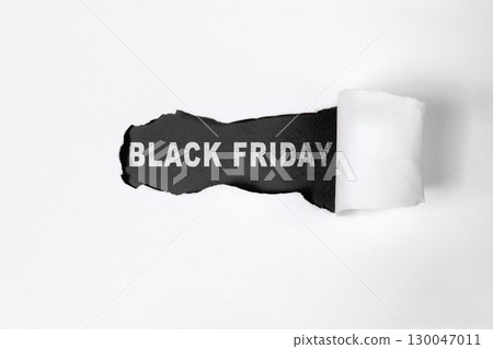 Top view of white ripped paper and text of Black Friday on a black background. Copy space. Flat lay. Black Friday sale concept 130047011