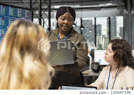 African american manager in corporate setting show empowerment through action, aligning insights with company strategy and vision to lead a project with her skilled coworkers team. African american manager in corporate setting show empowerment through action, aligning insights with company strategy and vision to lead a project with her skilled coworkers team. 130047196