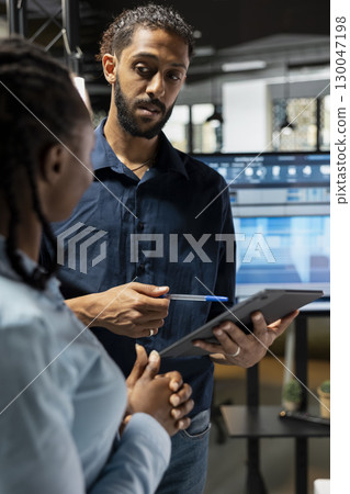 Urban developers engineers planning a residential project construction site, focusing on city planning and zoning regulations. Discuss real estate infrastructure growth during meeting. Urban developers engineers planning a residential project construction site, focusing on city planning and zoning regulations. Discuss real estate infrastructure growth during meeting. 130047198