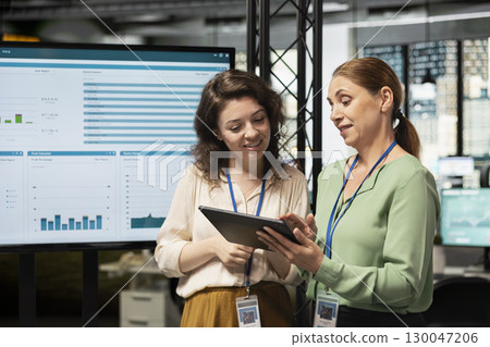 Empowered business associates planning a project with development goals, meeting in a boardroom to review data insights and performance indicators for multinational company growth. 130047206