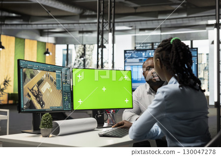 Black developers team preparing apartment building layout next to mockup screen, working at desk with dual monitors to design residential area after the construction project. Decorations software. Black developers team preparing apartment building layout next to mockup screen, working at desk with dual monitors to design residential area after the construction project. Decorations software. 130047278