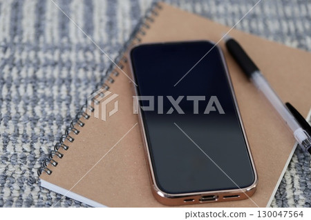 地毯上放置智慧型手機和書寫工具 130047564