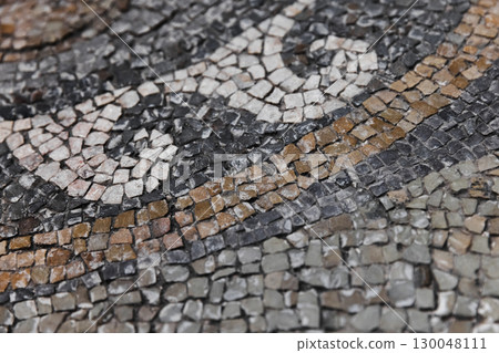 Ancient Roman mosaic displaying interwoven patterns of colorful stones Ancient Roman mosaic displaying interwoven patterns of colorful stones 130048111