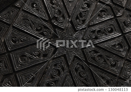 Black wood carving with ornate design featuring a detailed geometric pattern 130048113
