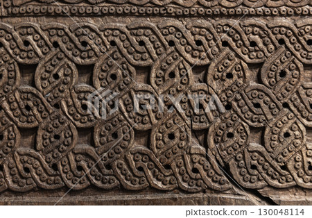 Detailed wooden panel featuring intricate hand-carved ornamental patterns Detailed wooden panel featuring intricate hand-carved ornamental patterns 130048114
