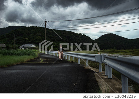 <Material> A woman walking along a river in the countryside after the rain <Material> A woman walking along a river in the countryside after the rain 130048239