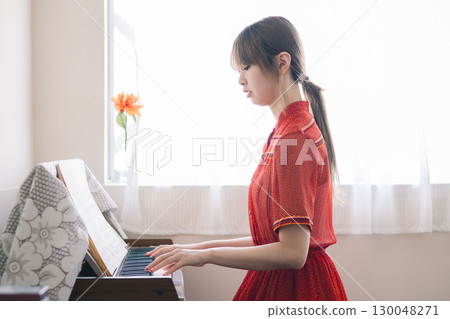 A woman playing the piano 130048271