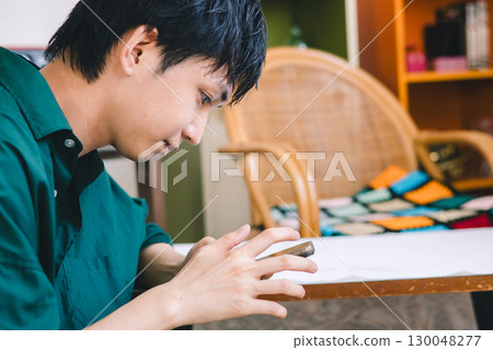 A young man looking at his smartphone 130048277