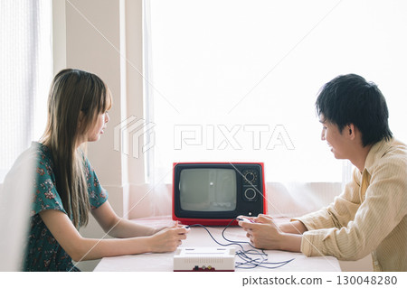 Men and women playing video games 130048280