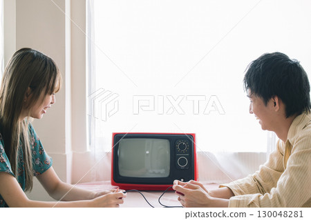 Men and women playing video games 130048281