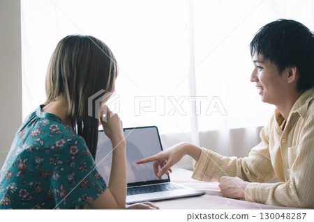 Men and women looking at a computer Men and women looking at a computer 130048287