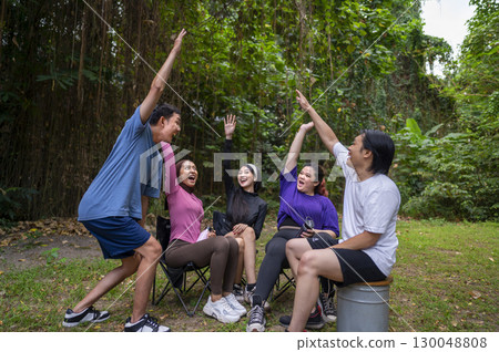 Indonesian southeast asian people in a sporty outfit, stacking hands together before practice exercise in a public park outdoors. Concept of a Healthy active lifestyle 130048808